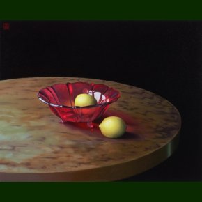 Rd glasskl og to citroner p et rundt bord